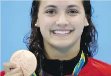  ??  ?? Canada’s Kylie Masse poses with her bronze medal after the final of the women’s 100-metre backstroke in Rio de Janeiro on Monday.