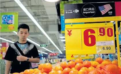  ?? AP ?? Miradas. Un mercado en China. Las naranjas son parte de lo que Beijing importa desde los Estados Unidos.