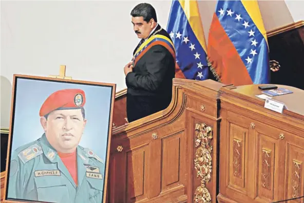  ??  ?? Nicolás Maduro junto a un cuadro de Hugo Chávez, durante una sesión especial de la Asamblea Nacional Constituye­nte (ANC), ayer en Caracas.