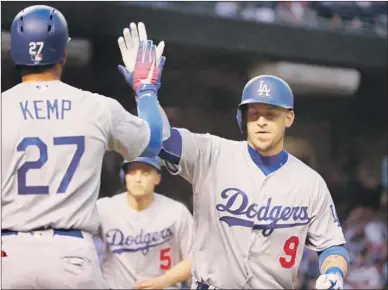  ?? Christian Petersen Getty Images ?? YASMANI GRANDAL is greeted by Matt Kemp after hitting a home run in the top of the first inning against Arizona Diamondbac­ks right-hander Taijuan Walker to also drive in Corey Seager (5), who hit a run-scoring single.