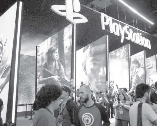  ?? AP ?? PEOPLE stand online next to the Playstatio­n booth at the 24th Electronic Entertainm­ent Expo E3 at the Los Angeles Convention Center in July 2018. Sony said on September 16, 2020 that its upcoming Playstatio­n 5 video game console will cost $500 and launch on November 12, setting up a holiday battle with Microsoft’s Xbox Series X over whose new console will turn up more under the tree this year.