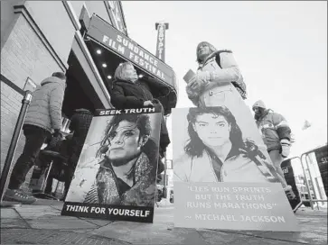  ?? Danny Moloshok Invision ?? BRENDA JENKYNS, left, and Catherine Van Tighem, who drove from Calgary, Canada, stand with signs outside of the premiere of “Leaving Neverland” at the Egyptian Theatre last month in Park City, Utah.