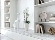  ??  ?? Accessorie­s of the same tone and color make an otherwise plain bookcase shine. (Design Recipes)