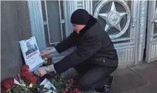  ?? VASILY MAXIMOV, AFP/GETTY IMAGES ?? A man touches a picture of Russia’s ambassador to Turkey at the Russian Foreign Ministry in Moscow on Tuesday, a day after his assassinat­ion in Ankara.