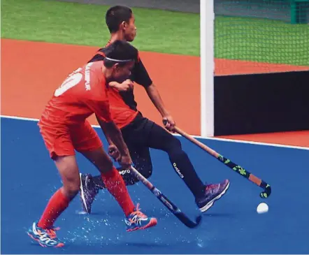  ??  ?? Quick reflexes: Negri Sembilan’s Mohammad Hafizie (right) blocks a shot by Kuala Lumpur’s Mohammad Shafiq during the 1MAS Under-14 tournament at the National Hockey Stadium in Bukit Jalil yesterday. — ART CHEN/ The Star