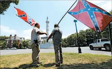  ?? STEVE HELBER/AP ?? Confederat­e flag bearers demonstrat­e in 2015 near the controvers­ial Monument Avenue in Richmond, Va.