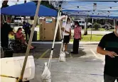  ?? HOWARD COHEN hcohen@miamiheral­d.com ?? People check in for second doses of the Pfizer vaccine at a FEMA-supported pop-up vaccine site at Ronselli Park Youth Center in Sweetwater on Thursday.