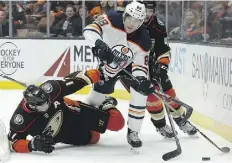  ?? ALEX GALLARDO/THE ASSOCIATED PRESS ?? Oilers defenceman Brandon Davidson contends with a fallen Ryan Kesler of the Ducks on Friday in Anaheim.