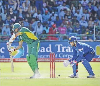  ??  ?? PORT ELIZABETH: South Africa’s opening batsman Hashim Amla (l) is watched by Sri Lanka’s wicketkeep­er Dinesh Chandimal (r) as he plays a shot during their One Day Internatio­nal (ODI) cricket match against Sri Lanka at St George’s Park yesterday, in...
