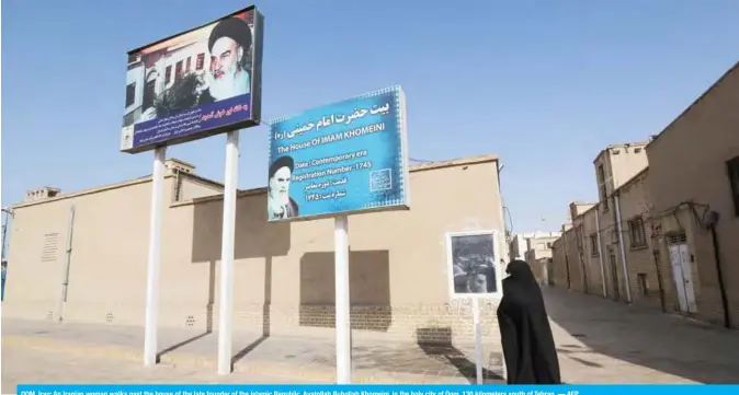  ?? — AFP ?? QOM, Iran: An Iranian woman walks past the house of the late founder of the Islamic Republic, Ayatollah Ruhollah Khomeini, in the holy city of Qom, 130 kilometers south of Tehran.