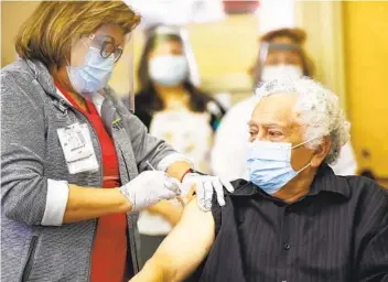  ?? K.C. ALFRED U-T ?? Carlos Alegre, de 72 años, residente a largo plazo del Centro de Enfermería Especializ­ada Birch Patrick en el Centro Médico Sharp de Chula Vista recibe una vacuna COVID-19 de la enfermera Virginia Vivar.