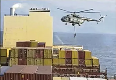  ?? ASSOCIATED PRESS ?? This image made from a video provided to The Associated Press by a Mideast defense official shows a helicopter raid in which paramilita­ry soldiers rappelled onto an Israeli-affiliated container ship they then seized near the Strait of Hormuz on Saturday, an attack attributed to Iran amid wider tensions between Tehran and the West.