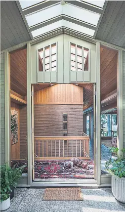  ?? STEVE RINGMAN PHOTOS TRIBUNE NEWS SERVICE ?? Oversized entry doors open to reveal a double-height entryway with a skylight that creates a warm and well-lit spot for a dog’s mid-day nap.