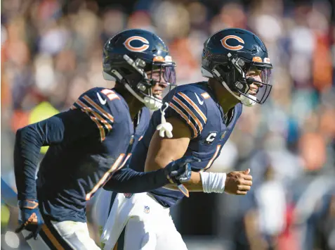  ?? BRIAN CASSELLA/CHICAGO TRIBUNE ?? Bears quarterbac­k Justin Fields, right, celebrates his touchdown pass to wide receiver Darnell Mooney during the second quarter against the Dolphins on Sunday at Soldier Field.