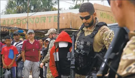  ?? EDMAR BARROS AP ?? Police officers escort a suspect toward a river Wednesday in the area where an Indigenous expert and freelance journalist disappeare­d.