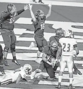  ?? James Nielsen / Houston Chronicle ?? Fort Bend Marshall quarterbac­k Jabari James, lower left, fumbles the ball, which is recovered in the end zone by College Station’s Anthony Flores for what proved to be the winning touchdown in the Cougars’ 31-27 victory Friday night.