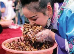  ??  ?? ... A Chinese woman takes part in an insecteati­ng competitio­n in the city of Lijiang, Yunnan province on Sunday.