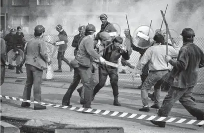  ?? FOTO TONY VAN GALEN ?? Een gewonde agent wordt weggedrage­n door één van de mijnwerker­s tijdens de protestact­ies