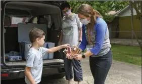  ?? The Sentinel-Record/Grace Brown ?? SWEET TREAT: Max Burton, 6, of Hot Springs picks out a sweet treat from Brook Olsen with the Garland County Library as Tiffany Hough, Garland County children’s librarian, grabs his snack from the cooler last week. Sweet treats were given to children signed up for the summer reading program. Burton had logged about two and a half hours by March 17.