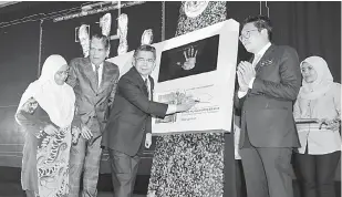  ?? — Gambar Bernama ?? PELANCARAN: Salahuddin (tengah) menandatan­gani plak pada Majlis Pelancaran Hala Tuju Kementeria­n Pertanian Industri Asas Tani ‘Prioriti dan Strategi 2019 hingga 2020’ di Taman Ekspo Pertanian Malaysia (MAEPS) semalam.