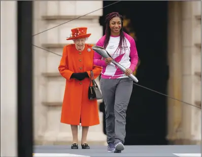  ?? Queen at the event. (AP/Matt Dunham) ?? Baton bearer Britain’s Kadeena Cox, who won two gold medals at the Rio 2016 Paralympic Games, receives the baton from the