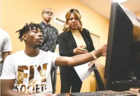  ?? STAFF PHOTO BY TIM BARBER ?? Darius Hurd, left, displays his résumé for director of recruiting Marlena Russell Thursday at the American Job Center Tennessee in Eastgate Town Center. Recruiter Travis Brewer watches from behind.