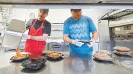  ??  ?? Above, Miguel Gonzales, left, and Oscar Garcia prepare lunch at Piero’s Pizza before they go to Kipling Elementary School.