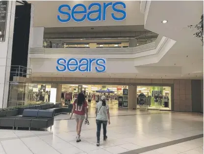  ?? JOE LEWNARD/DAILY HERALD (ABOVE); DAILY HERALD FILE PHOTO (RIGHT) ?? ABOVE: Sears at Woodfield Mall in 2019. RIGHT: Miss Illinois 1971, Anita Joyce Pankratz, store manager John Maloney (left) and Sears Midwestern vice president Culver Kennedy (second from right) officially open the Sears store at Woodfield Mall in Schaumburg on Aug. 4, 1971.