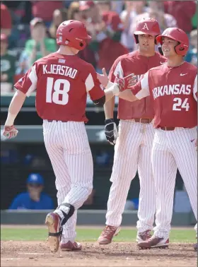  ?? NWA Democrat-Gazette/ANDY SHUPE ?? Arkansas left fielder Heston Kjerstad (18) is congratula­ted at the plate by Dominic Fletcher (24) and Jordan McFarland after hitting a three-run home run Saturday during the third inning of a first-game victory at Baum Stadium in Fayettevil­le.