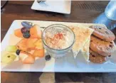  ?? ?? A compliment­ary small plate at Stir includes mint-infused fruit (melon bites, grapes, blueberrie­s), a small serving of homemade chicken salad (accompanie­d by bread wedges) and three chocolate chip cookies.