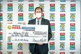  ?? .( Michigan Lottery via AP) ?? Attorney Kurt Panouses poses with a check on behalf of the winners of a Mega Millions lottery jackpot Feb. 26 in Lansing, Mich. Four people in a suburban Detroit lottery club have won the$1.05 billion Mega Millions lottery jackpot and will share $557 million after taxes. Officials made the announceme­nt Friday, nearly two months after the Jan .22, drawing