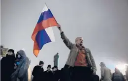  ?? PAVEL GOLOVKIN/AP ?? A man waves a Russian national flag during a protest Monday against the results of the parliament­ary election in Moscow. Videos of ballot fraud have surfaced.