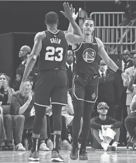  ?? KELLEY L COX/USA TODAY SPORTS ?? Jordan Poole high-fives Draymond Green after a play against the Dallas Mavericks in the 2022 playoffs.