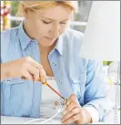  ?? Getty Images ?? A woman wires an electrical plug.