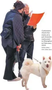  ?? WANG GANG / FOR CHINA DAILY ?? Customers check the menu at a pet-friendly restaurant in Shanghai in February, 2023.