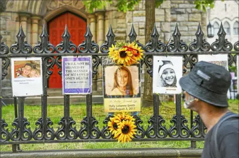  ?? Steve Mellon/Post-Gazette ?? A man reads the captions on some of the more than 100 pictures of overdose victims on display at the “Say Their Name” exhibit in August at Trinity Episcopal Cathedral, Downtown.