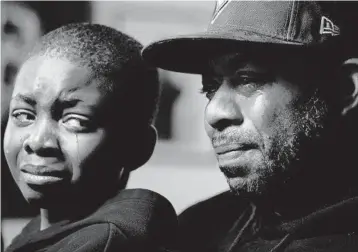  ?? MATT ROURKE/AP PHOTOS ?? Wayne Jones, holding his son Donell, speaks about his mother Celestine Chaney. She was one of 10 Black people killed in a mass shooting Saturday at a supermarke­t in Buffalo, N.Y. She had gone there looking to buy shortcakes.