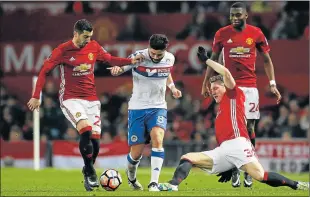  ?? Picture: REUTERS ?? TOUGH ODDS: Wigan Athletic's Sam Morsy tries to take the gap between Manchester United's Henrikh Mkhitaryan, left, and Bastian Schweinste­iger