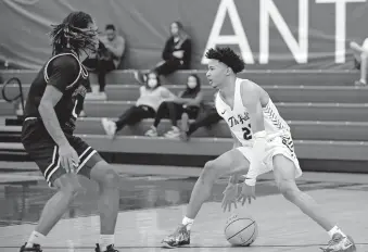  ?? PHIPPS/ THE OKLAHOMAN] [SARAH ?? Heritage Hall's Trey Alexander looks to get by Midwest City's Makale Smith during a game Jan. 22.