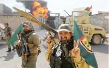  ??  ?? TAL AFAR: Fighters of Hashed Al-Shaabi (Popular Mobilizati­on units) flash the victory gesture as they advance through a street in the town of Tal Afar, west of Mosul, after the Iraqi government announced the launch of the operation to retake it from...