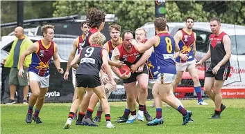  ?? ?? Warragul’s Dale Carroll (centre) tries to break through a swarm of players with ball-in-hand. Photograph­s by CRAIG JOHNSON.