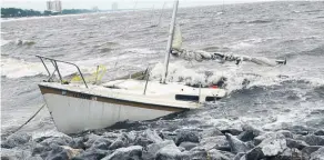  ?? Picture / AP ?? An abandoned boat takes on water on the Mississipp­i Gulf Coast near Biloxi as outer bands of Hurricane Nate batter the shore.