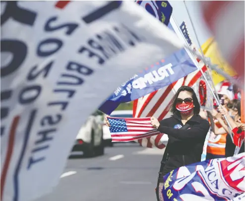  ?? ALEX EDELMAN / AFP via Gett y Imag es ?? Supporters of U. S. President Donald Trump hold signs and flags on Sunday outside of Walter Reed Medical Center
in Bethesda, Md., hoping to relay “positive energy” to Trump as he battles the coronaviru­s.