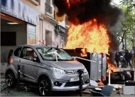  ??  ?? Des voitures incendiées et des dégradatio­ns importante­s ont émaillé le défilé du er-Mai, hier à Paris. (Photo AFP)