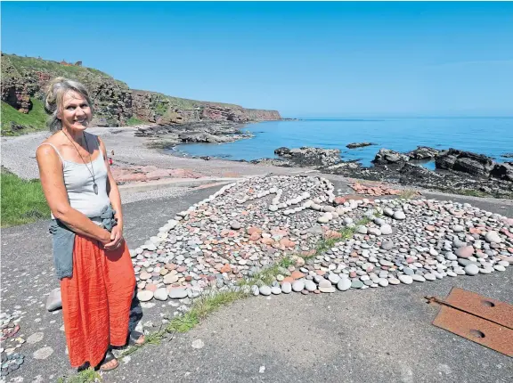  ?? Pictures: Dougie Nicolson. ?? Artist Mary-ann Orr beside the stone loveheart tribute to NHS workers close to the harbour at Auchmithie.