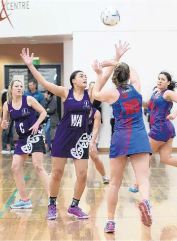  ?? PHOTO: LINDA ROBERTSON ?? Pass off . . . UniAlbion wing defence Zoe Honeyfield looks to pass the ball to wing attack Ashley Tahiwi while South Pacific Titans’ players Dayna Turnbull (left) and Dora Nafatali look to intervene at the Edgar Centre on Saturday.