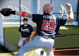  ?? CURTIS COMPTON / CCOMPTON@ AJC. COM ?? Tyler Flowerswor­ks on a drill in the bullpen Saturdaywi­th newcatchin­g partner Travis d’arnaud looking on in North Port, Florida.