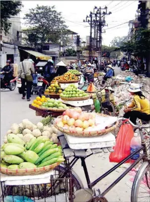  ?? BÙI TUONG/VIET NAM NEWS ?? Street vendors sell fruits and vegetables at a makeshift market on Dông Tác Street, Dong Da district, Hanoi.