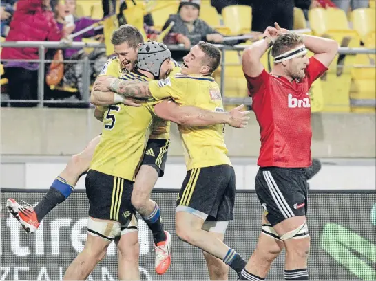 ?? Photo: FAIRFAX NZ ?? Jubilation: Hurricanes No 8 Blade Thomson, centre, is hugged by team-mates Cory Jane, left, and TJ Perenara after scoring his second try during Saturday’s 16-9 win over the Crusaders at Westpac Stadium. Crusaders No 8 Kieran Read shows his...