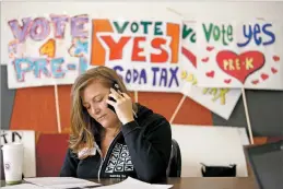  ?? PHOTOS BY LUIS SÁNCHEZ SATURNO/THE NEW MEXICAN ?? Emily Kaltenbach, a volunteer with Pre-K Santa Fe, makes calls Saturday afternoon on behalf of the proposed tax.